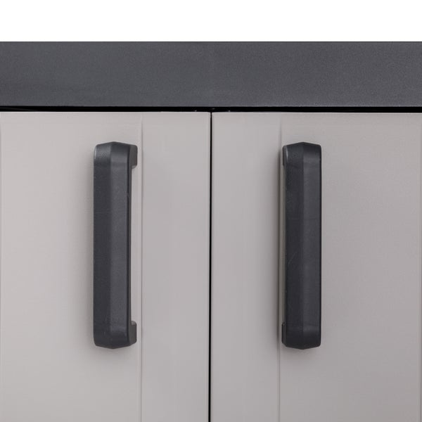 Detailansicht eines Schranks mit zwei grauen Türen und schwarzen Griffen