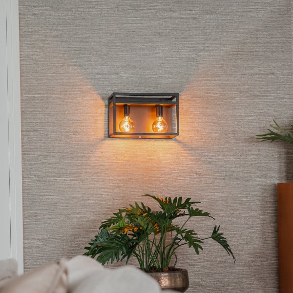 Wandleuchte mit zwei Glühbirnen in einem schwarzen Metallrahmen