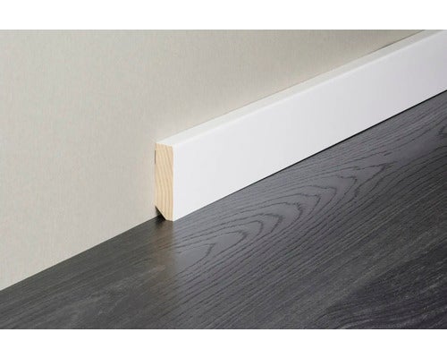 Weiße Sockelleiste aus Holz mit rechteckigem Profil und abgeschrägter Oberkante, montiert auf dunklem Boden in Holzoptik.