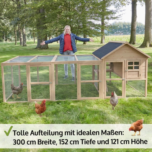 Großer Hühnerstall aus Holz mit angebautem Freigehege aus Drahtgeflecht und Fenster auf einer Wiese.