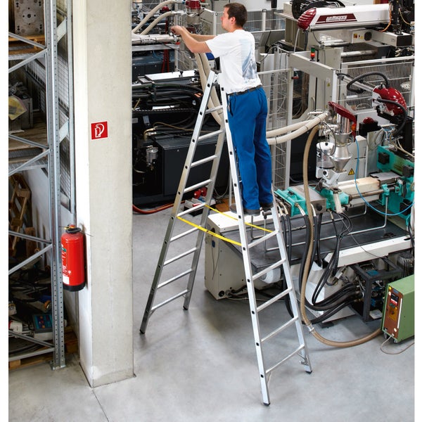 Eine Person steht auf einer ZARGES Stufenleiter in einer Industrieanlage.