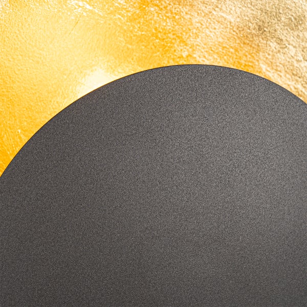 Nahaufnahme eines runden, dunklen Objekts vor einem goldenen Hintergrund