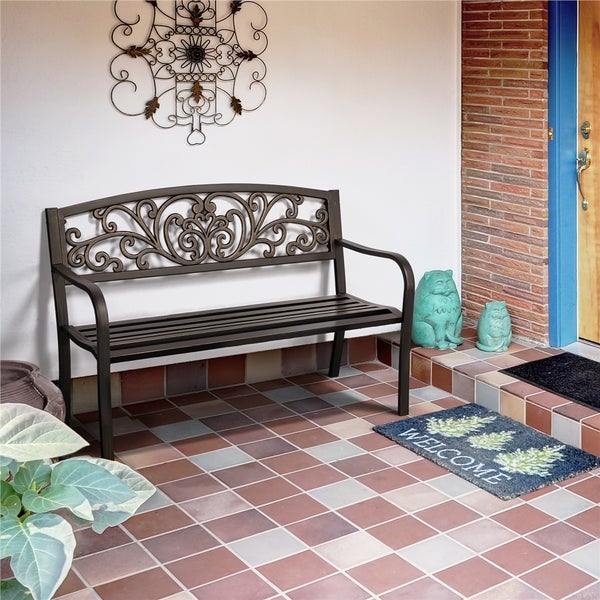 Dekorativer Sitzbereich mit Gartenbank, Wanddeko und Fußmatte vor einer Haustür