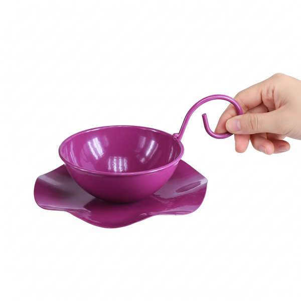 Lilafarbener Pflanztopf aus Metall in Teetassenform mit gewelltem Untersetzer, gehalten von einer Hand.