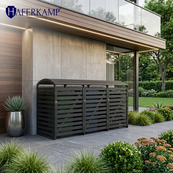 Moderne Mülltonnenbox aus Holz für drei Mülltonnen, aufgestellt auf einer gepflasterten Terrasse vor einem modernen Wohnhaus.
