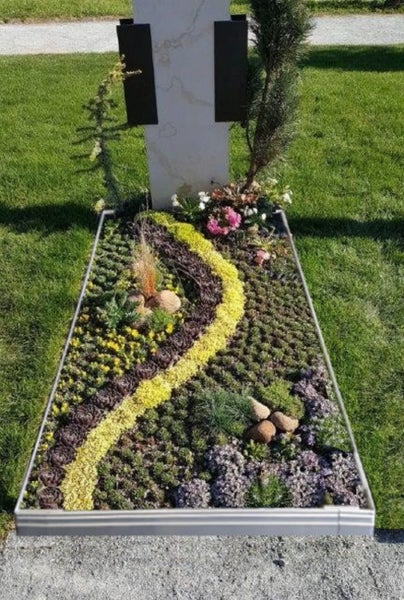 Grab mit Grabstein, Pflanzen und Dekoration