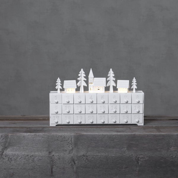Beleuchteter, weißer Adventskalender mit 24 Schubladen, Häusern und Tannenbäumen