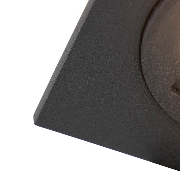 Detailaufnahme einer dunklen, strukturierten, matten Oberfläche mit einer Ecke und einer runden Aussparung.