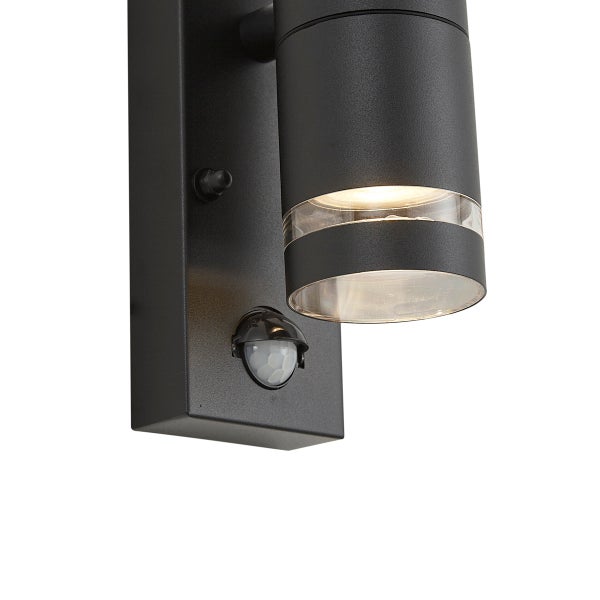 Schwarze Außenwandleuchte in zylindrischer Form mit integriertem Bewegungsmelder und warmweißem Licht.