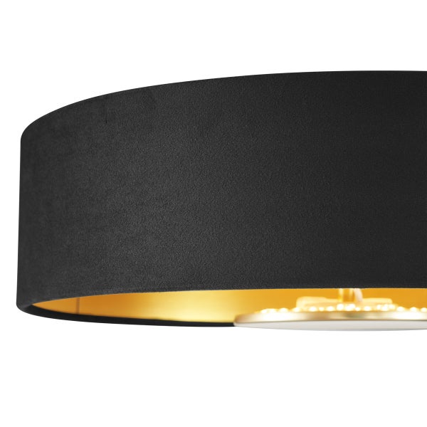 Nahaufnahme einer Deckenleuchte mit schwarzem Textilschirm und goldener Innenseite.