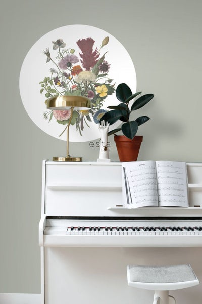 Dekoratives Wandtattoo mit Blumenmotiv über einem weißen Klavier