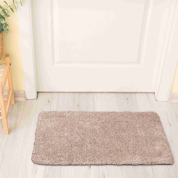 Rechteckige Fußmatte vor einer Tür auf einem hellen Holzboden