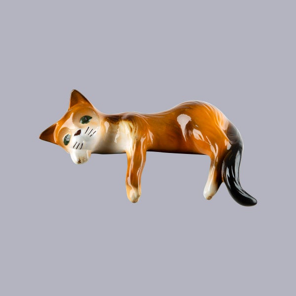 Keramik-Dekofigur Katze, liegend, braun, weiß und schwarz.