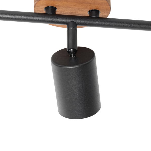 Detail einer schwarzen Deckenschiene mit Holzapplikation und einem verstellbaren Strahler