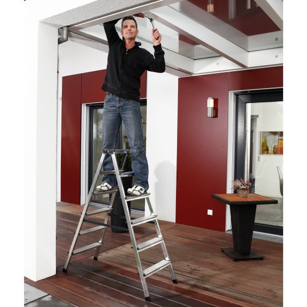 Mann auf einer Stufenleiter bei der Installation einer Terrassenüberdachung.