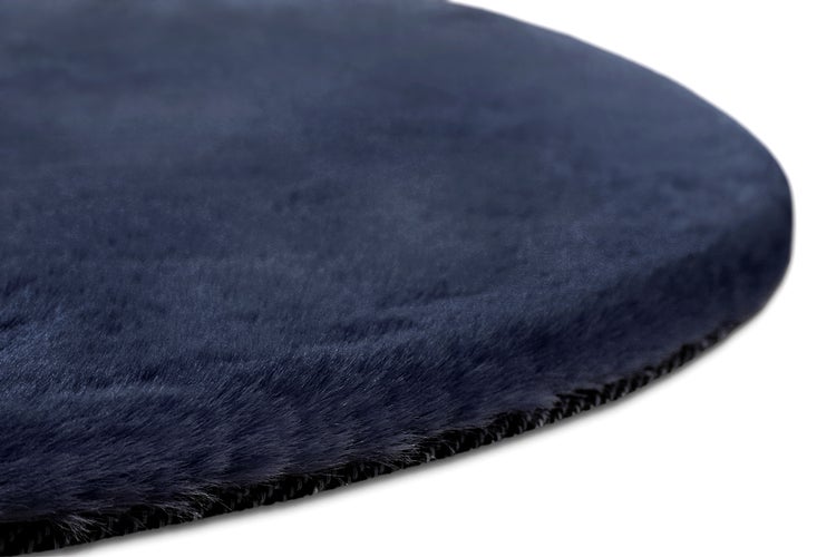 Nahaufnahme eines runden Sitzkissens aus weichem blauem Kunstfell mit Kettelrand.