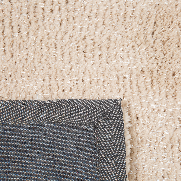 Nahaufnahme eines beigen Hochflor-Teppichs mit weichem Flor und grauer gewebter Rückseite.