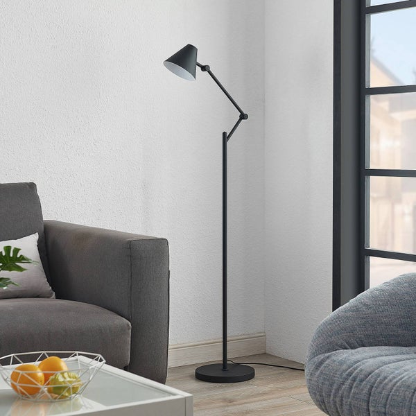 Stehlampe im Wohnzimmer neben Sofa und Sessel