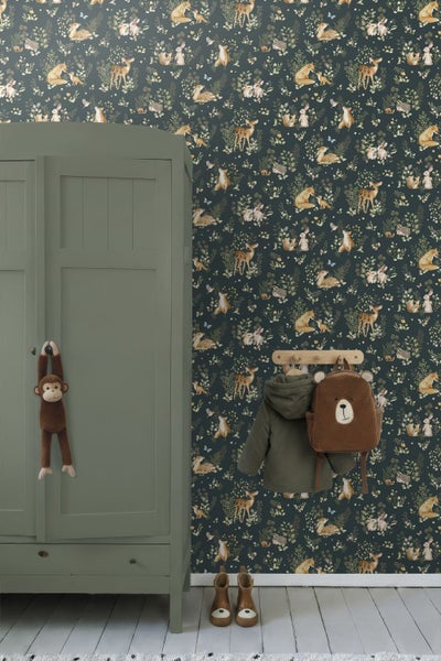 Kinderzimmer mit Waldtiere-Tapete, einem grünen Kleiderschrank aus Holz, einer Garderobe mit Jacke und Bären-Rucksack.