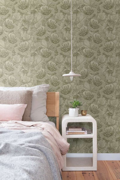 Schlafzimmer mit blumiger Mustertapete und Holzbetten, Nachttisch mit Pflanze sowie einer hängenden Deckenleuchte.