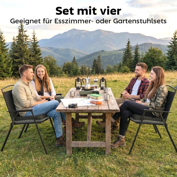 Vier Personen auf Gartenstühlen mit dunkelgrauen Sitzkissen an Holztisch im Freien mit Bergblick. Set mit vier Kissen für Esszimmer oder Garten.