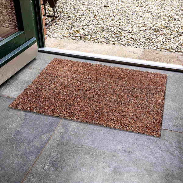 Fußmatte vor einer Haustür auf Steinfliesen