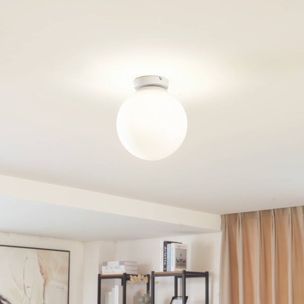 Weiße kugelförmige Deckenleuchte an einer Zimmerdecke in einem hellen, modernen und organisierten Wohnraum.