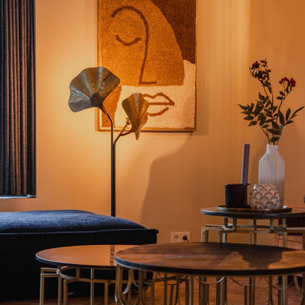 Wohnzimmer mit Stehlampe, Couchtisch und Wandbild