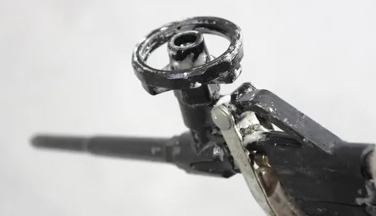 Nahaufnahme einer Bauschaumpistole aus Metall mit Einstellrad und Abzugshebel.