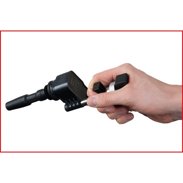 Eine Hand hält eine Zündspule.