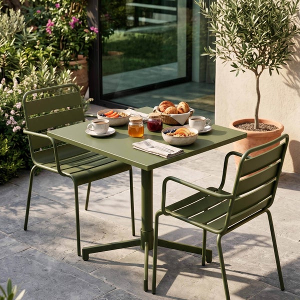 Grünes Gartenmöbel-Set aus Metall mit einem quadratischen Tisch und zwei Stühlen auf einer Steinterrasse, modern und schlicht gestaltet.