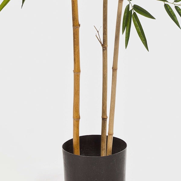 Nahaufnahme einer künstlichen Bambuspflanze mit detailreichen grünen Blättern und naturgetreuen Bambusstämmen.