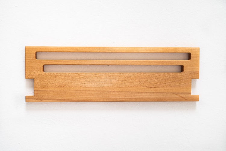 Messerleiste aus Buchenholz zur Wandmontage mit horizontalen Aussparungen für Küchenutensilien.