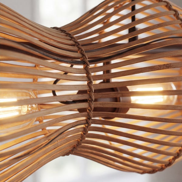 Nahaufnahme einer Pendelleuchte aus geschwungenen Bambuslamellen mit zwei leuchtenden Glühbirnen.