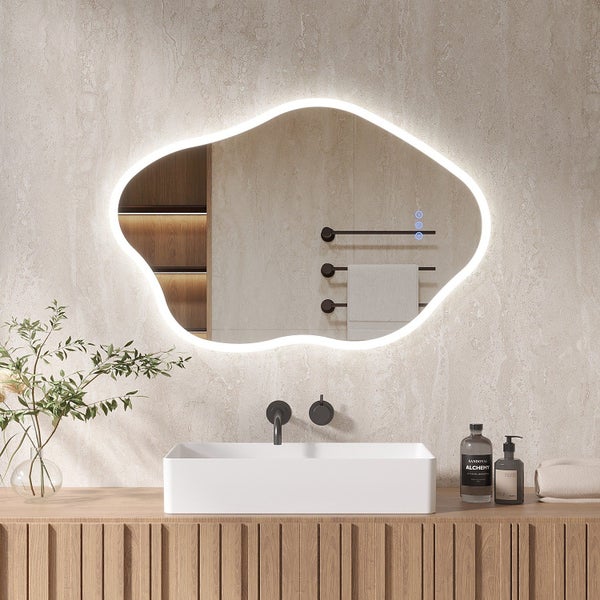 Organisch geformter Badezimmerspiegel mit umlaufender LED Beleuchtung und Touch Steuerung über einem Waschbecken mit Waschtischunterschrank.