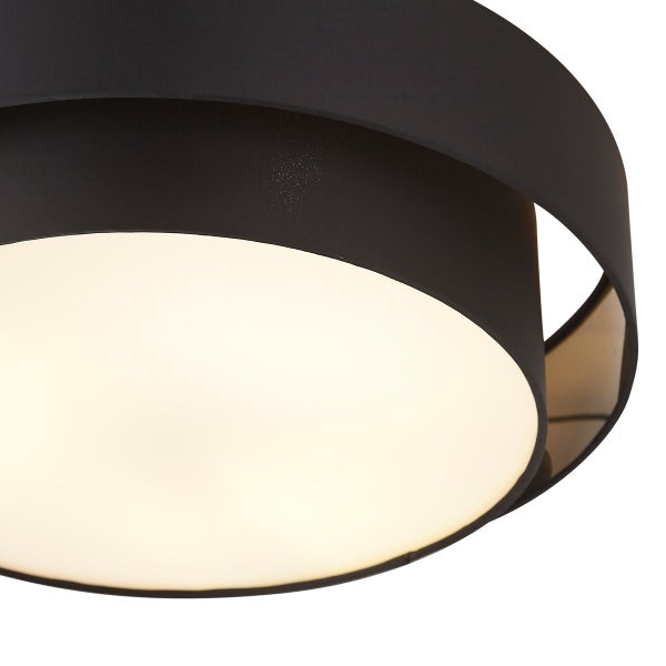 Nahaufnahme einer modernen runden Deckenleuchte mit schwarzem Außenschirm und beleuchtetem Diffusor.