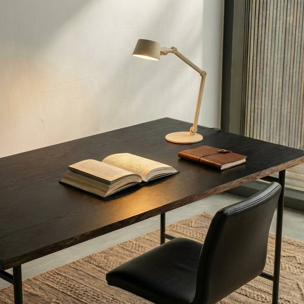 Schreibtisch mit Schwenkarmleuchte, Buch und Notizbuch