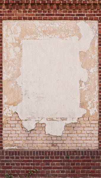 Backsteinmauer mit beschädigtem Putz