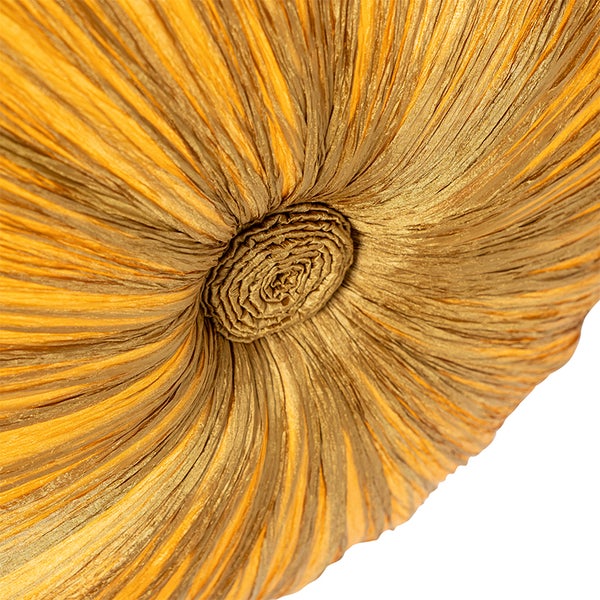 Nahaufnahme eines runden Dekokissens aus plissiertem Stoff mit zentraler Raffung.