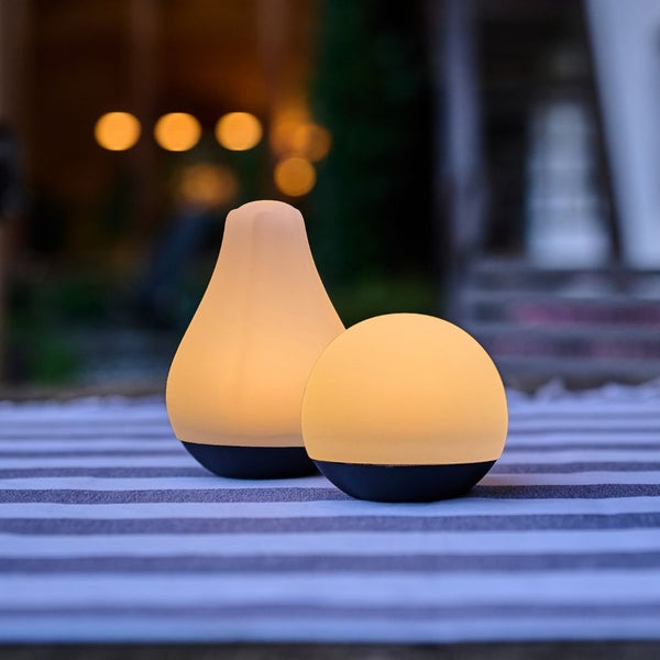 Zwei Leuchten in Tropfen- und Kugelform für den Außenbereich auf einem gestreiften Teppich