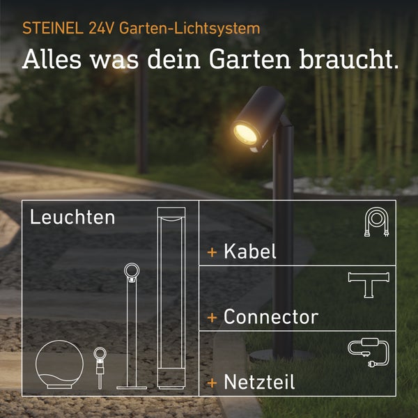 Steinel 24 Volt Garten-Lichtsystem mit Leuchten, Kabel, Verbinder und Netzteil in einer Gartenumgebung bei Nacht.