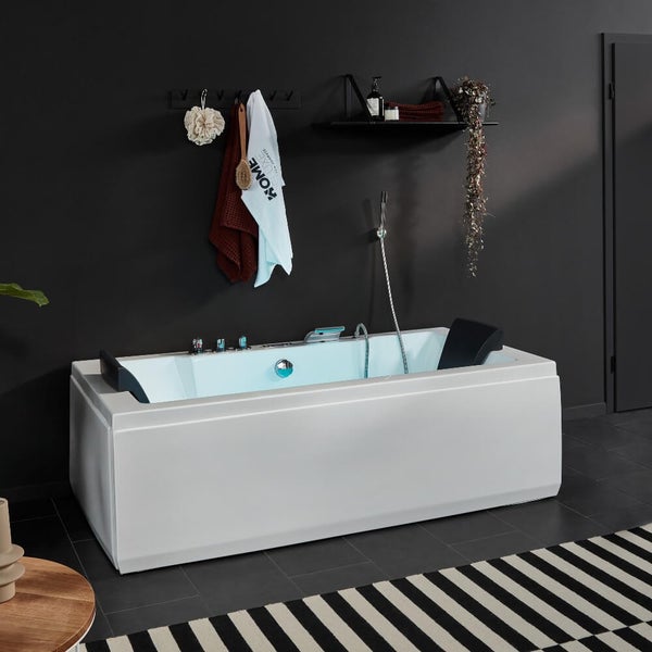 Moderne rechteckige Badewanne mit Armaturen und Kopfstützen in einem minimalistischen Badezimmer.