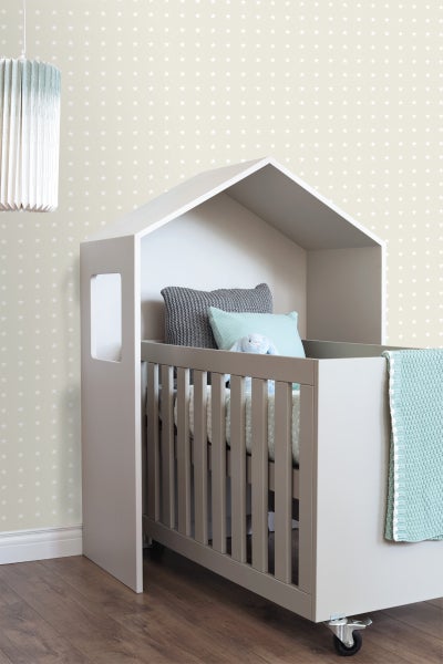 Babyzimmer mit Hausbett auf Rollen, Kissen und Decke