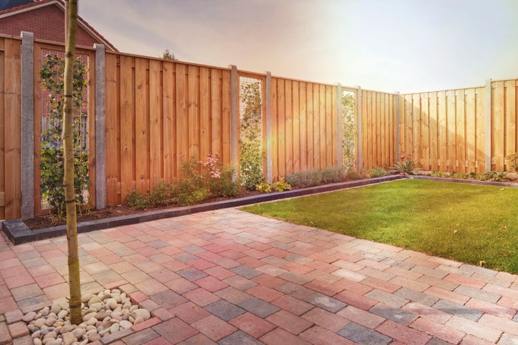 Garten mit Holzzaun, Rasenfläche und gepflastertem Weg