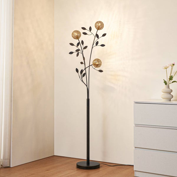 Dekorative Stehlampe mit Blattdesign und drei Kugellampen im Wohnraum