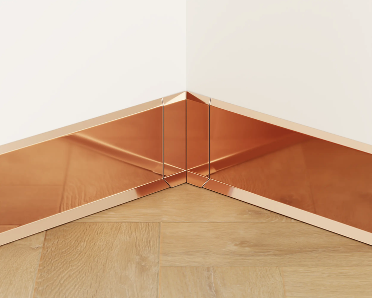 Detailaufnahme von Sockelleisten an einer Ecke zwischen Wand und Holzboden