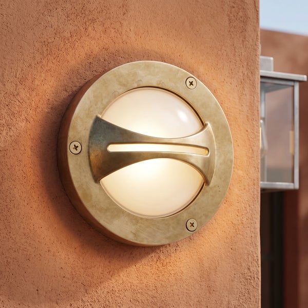 Runde Außenwandleuchte aus Metall mit dekorativer Blende und mattem Glasdiffusor für eine atmosphärische Fassadenbeleuchtung