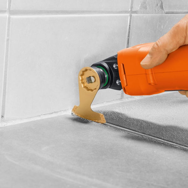 Oszillierendes Elektrowerkzeug im Einsatz zum Entfernen von Fugenmasse zwischen Fliesen