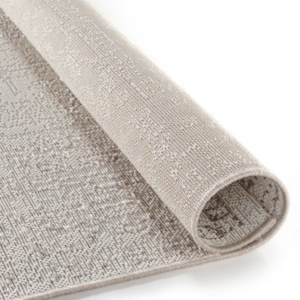 Aufgerollter flachgewebter Teppich mit grober Struktur in meliertem Beige.
