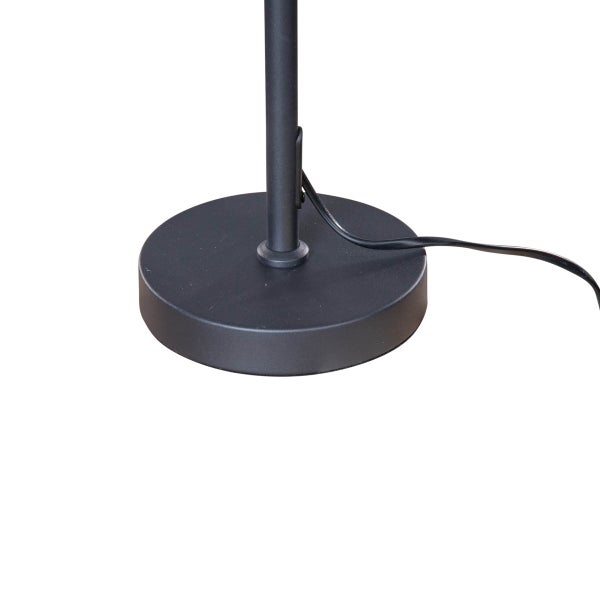 Detailaufnahme des schwarzen Metallfußes einer Stehlampe mit Kabel